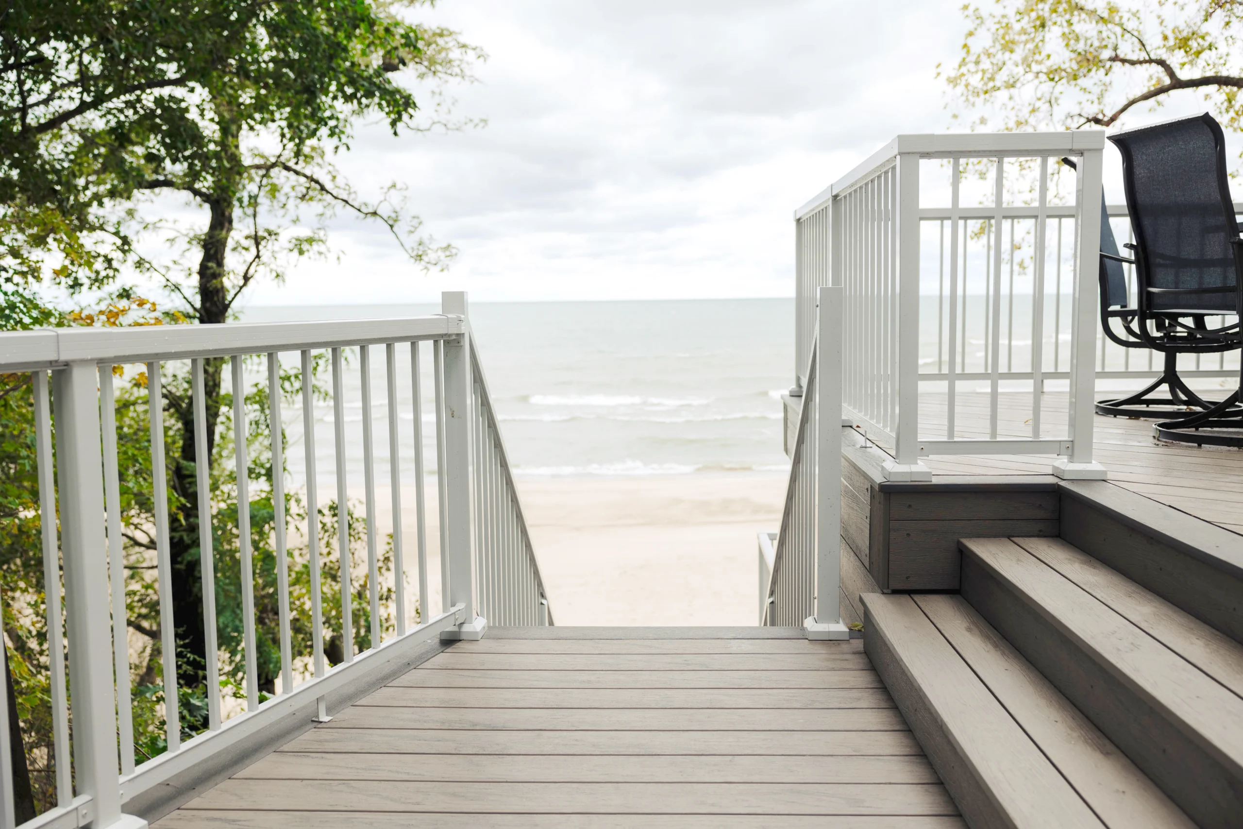 Composite deck overlooking lake with stairs and railing showcasing TruNorth Accuspan composite decking durability and low maintenance performance