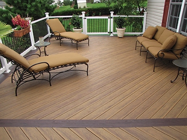 TruNorth Clubhouse Ultra PVC decking in Ipe with Mahogany accent boards on a backyard deck with outdoor seating