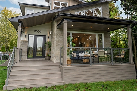 TruNorth Clubhouse Ultra PVC decking in Hickory on a modern backyard deck with covered patio and glass railing