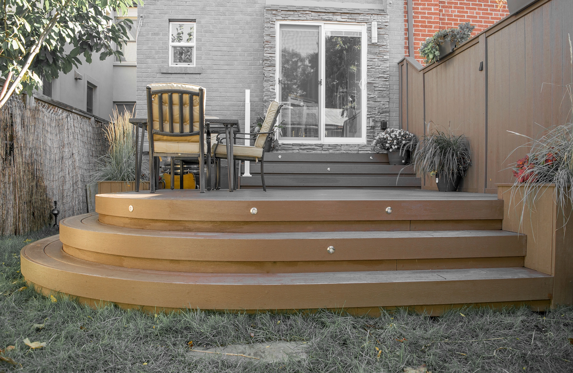Curved composite deck steps with warm brown boards in a modern backyard setting